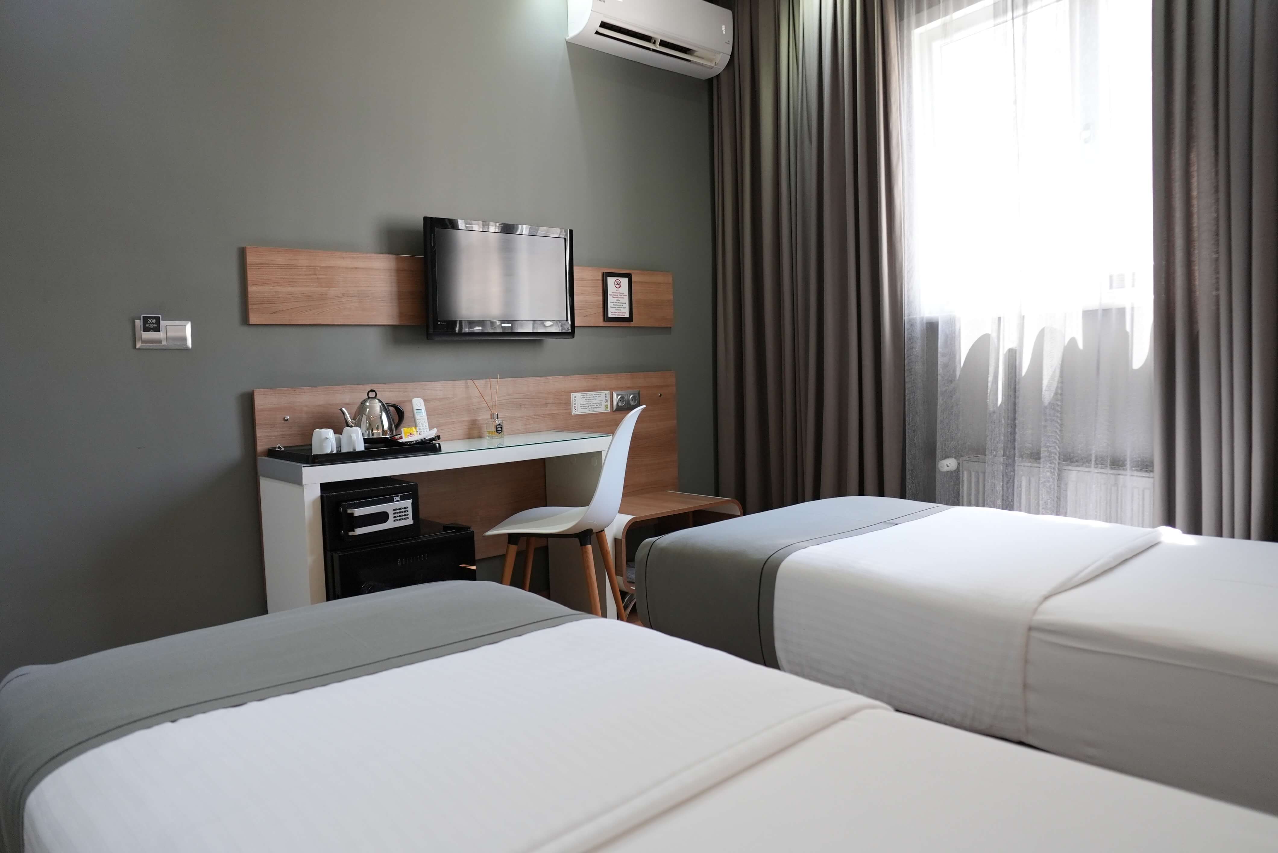 Standard twin: desk, TV and tea tray seen from the bedside